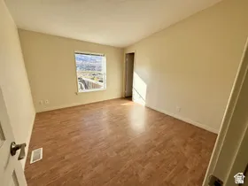 Bright interior with wood-finish flooring, neutral wall tones, and a window offering a scenic backdrop