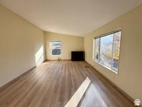 Vaulted ceiling, wood-finish flooring, and multiple windows