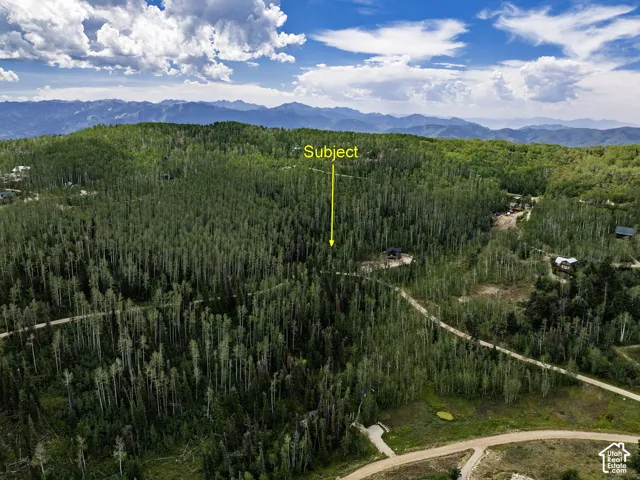 Wooded lot with surrounding mountain ranges and established roadways