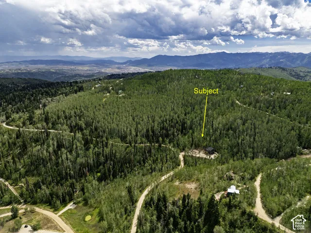 Expansive wooded lot with mountain backdrop and surrounding natural landscape