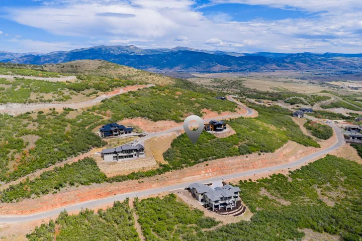 Mountainous backdrop, residential development, winding roads, scattered homes, elevated topography