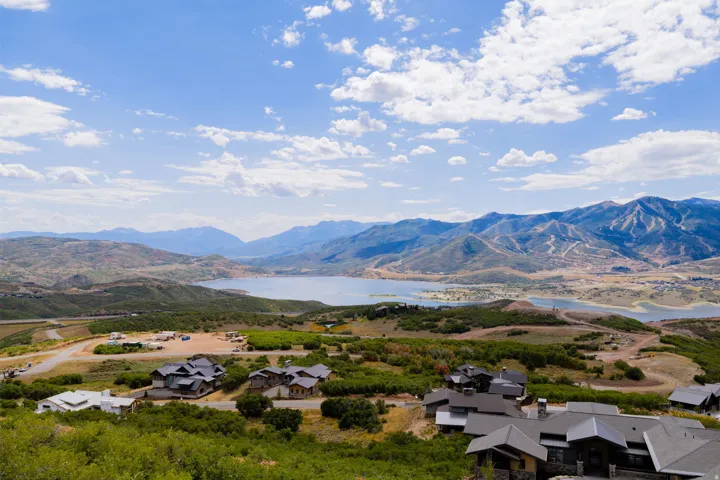Expansive mountainous landscape with a prominent lake and residential properties