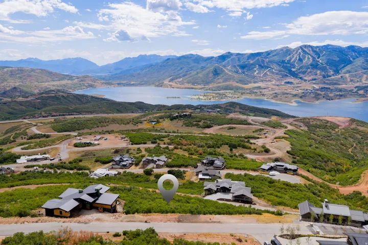 Mountainous terrain with natural vegetation, a large lake, and distant ski slopes