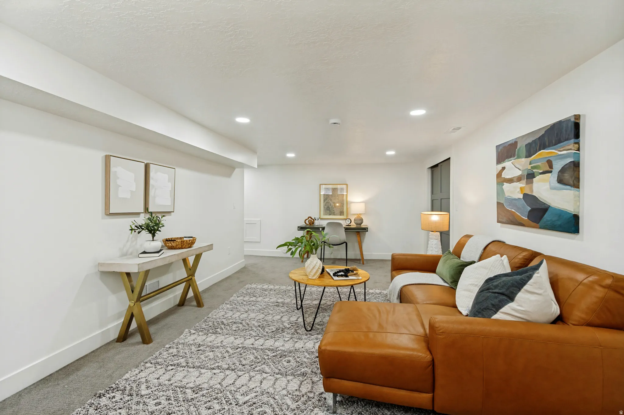 Recessed ceiling lighting, textured wall finishes, and a gray carpeted floor