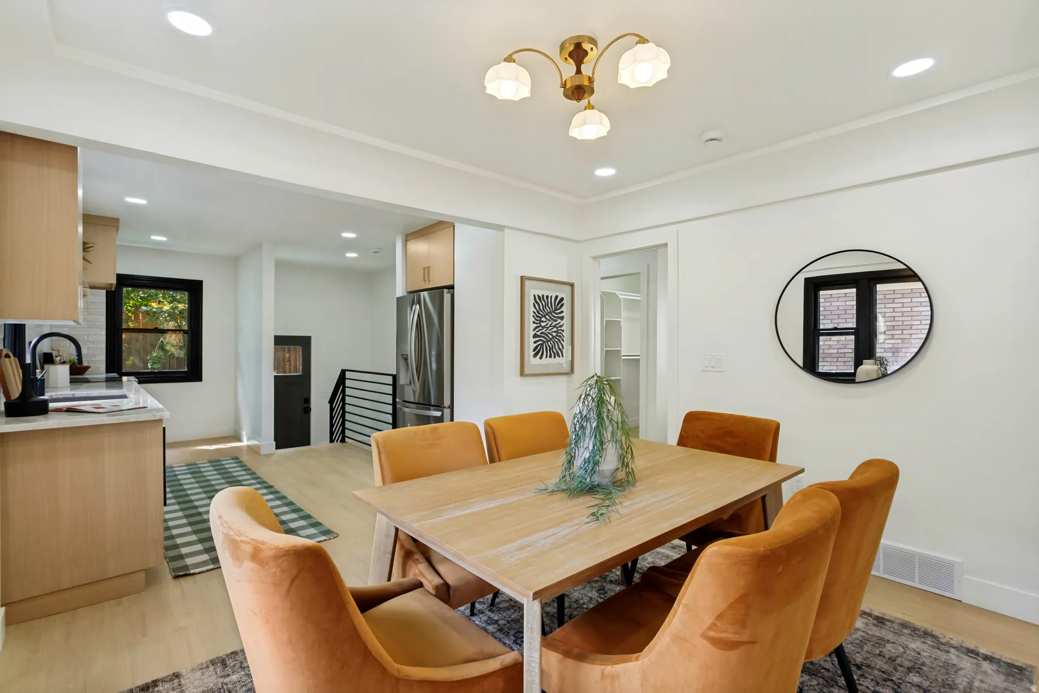 Open concept living space featuring recessed lighting, a modern chandelier, wood-finish flooring, and crown molding