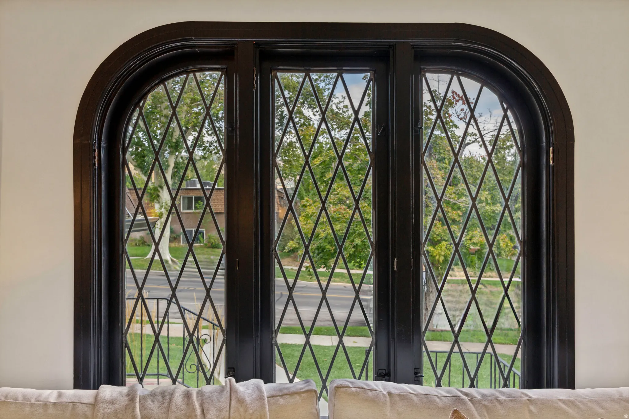 Arched window featuring diamond-patterned muntins and dark-finished trim