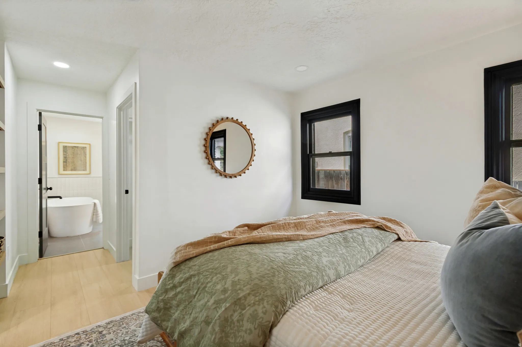 Light wood-finish flooring, recessed lighting, and black-framed windows