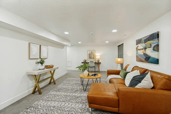 Recessed ceiling lighting, textured wall finishes, and a gray carpeted floor