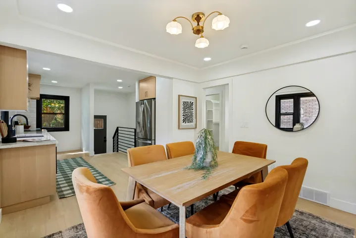 Open concept living space featuring recessed lighting, a modern chandelier, wood-finish flooring, and crown molding