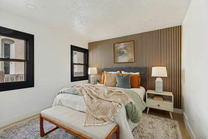 Accent wall with vertical wood paneling, recessed ceiling lighting, and black-framed windows