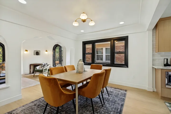 Sophisticated dining room featuring a wood-finish dining table paired with upholstered chairs in warm cognac tones