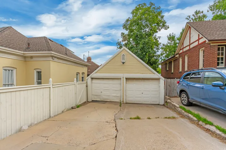 Two-car detached garage with panel doors and horizontal siding