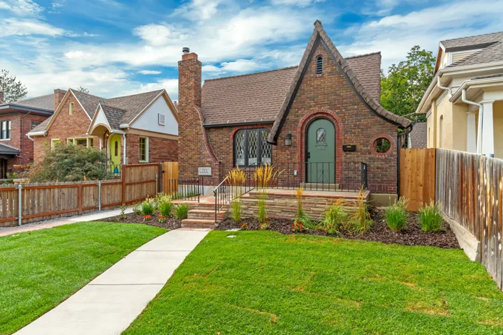 Brick facade with a prominent chimney, arched entryway, and dark-framed windows