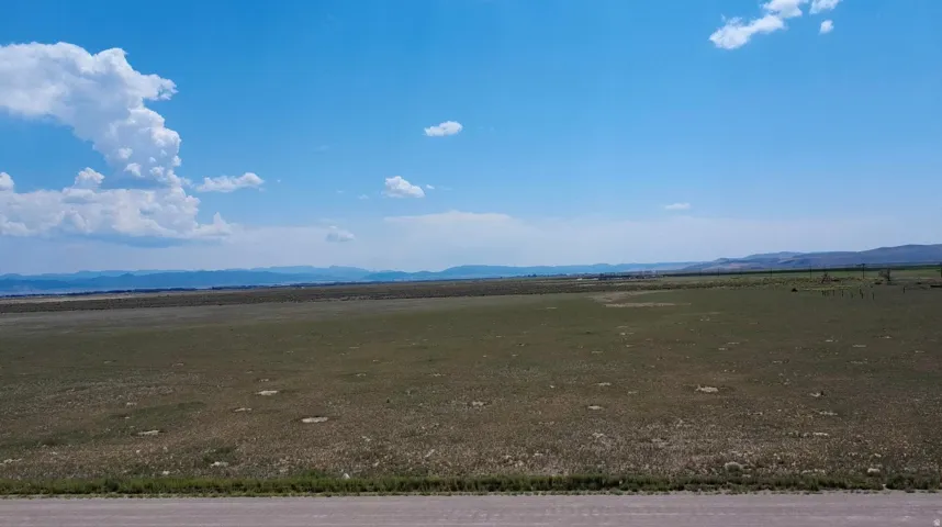 Expansive open land with distant mountain ranges and clear sky