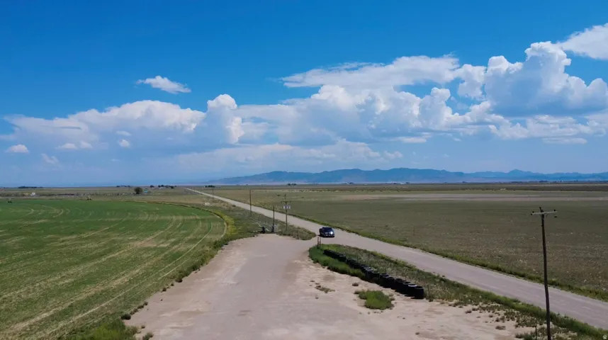 Expansive open fields with distant mountain ranges and a clear sky