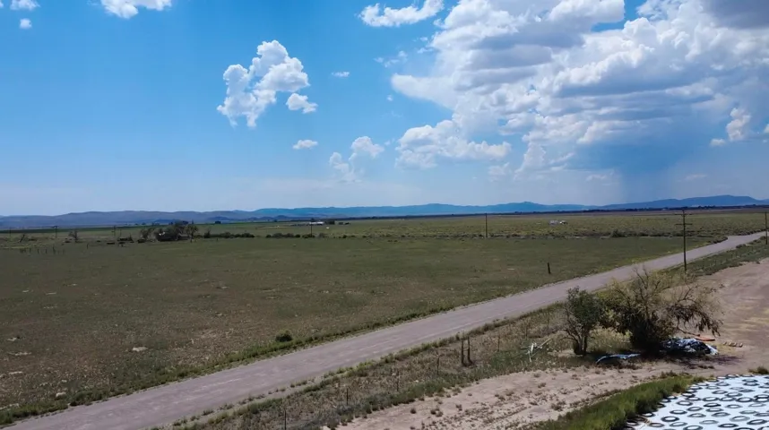 Expansive open land with a gravel road and distant mountains