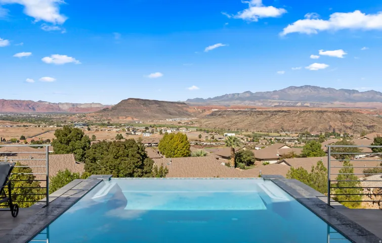 Infinity-edge swimming pool with turquoise water and integrated spa jets overlooking expansive valley landscape