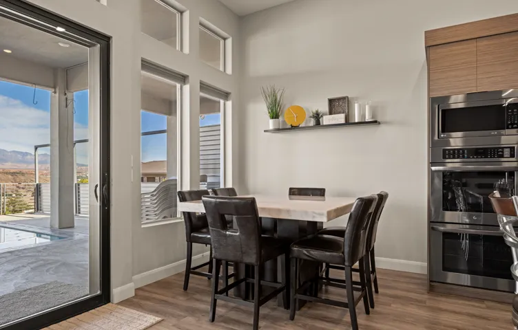 Dining area featuring a wood-finish table with seating for four, complemented by black upholstered chairs