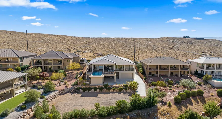 Expansive hilltop residence featuring multiple connected structures with modern architecture, resort-style swimming pool, and mature landscaping throughout the grounds