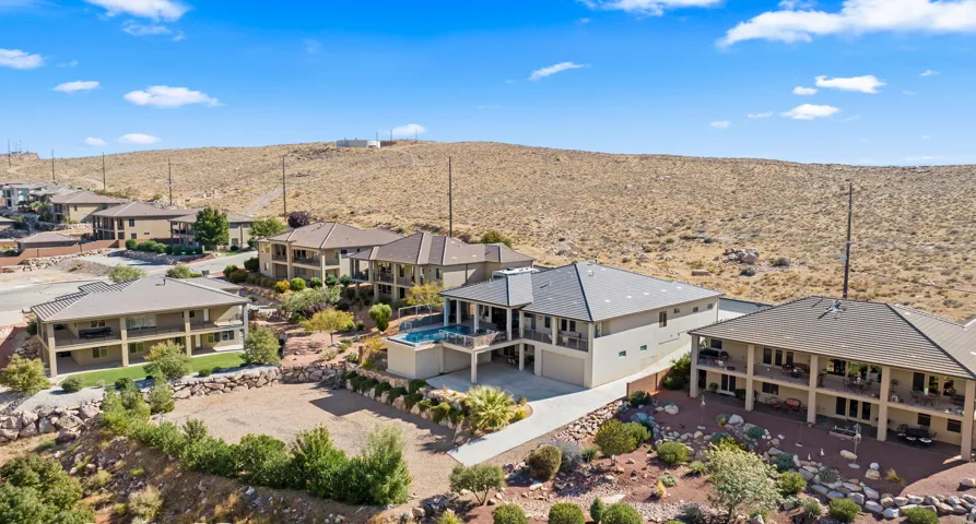 Modern desert landscape featuring multi-story residences, tiered outdoor living spaces, and an integrated swimming pool