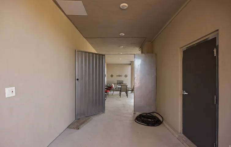 Hallway featuring recessed lighting, a corrugated metal door, and a solid gray door