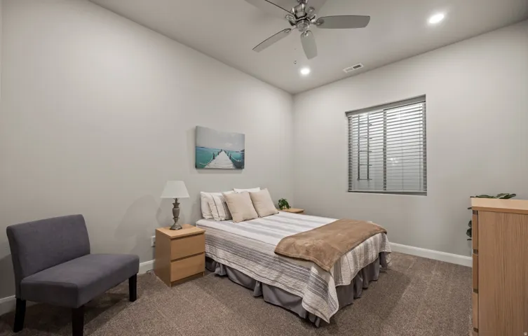 Bright secondary bedroom featuring neutral wall finishes, recessed ceiling lighting, and a ceiling fan