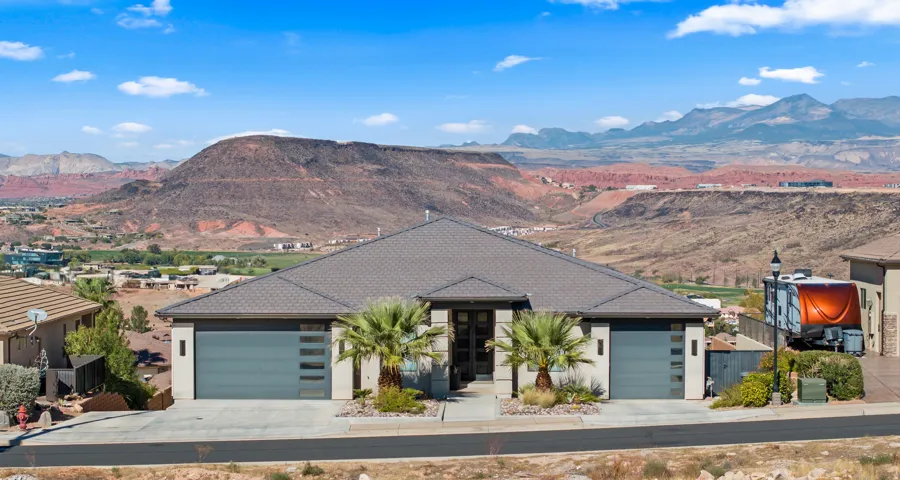 Contemporary exterior featuring a low-slope roofline, a two-car garage with frosted glass panels, and desert-adapted landscaping