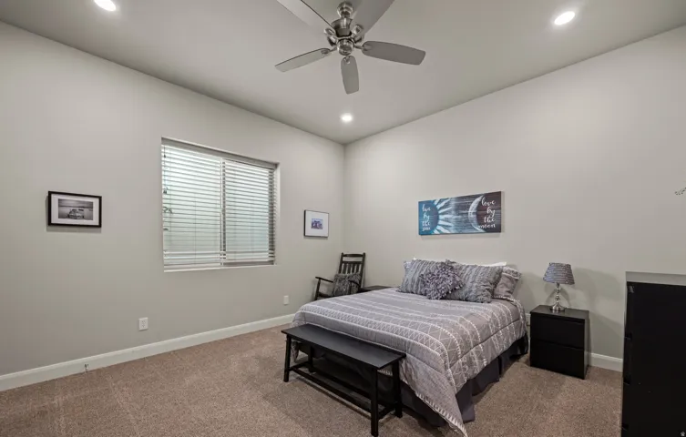Carpeted room featuring a ceiling fan, recessed lighting, and a window with blinds