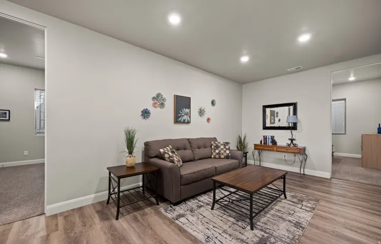 Bright, open living space anchored by recessed ceiling lighting and neutral wall finishes