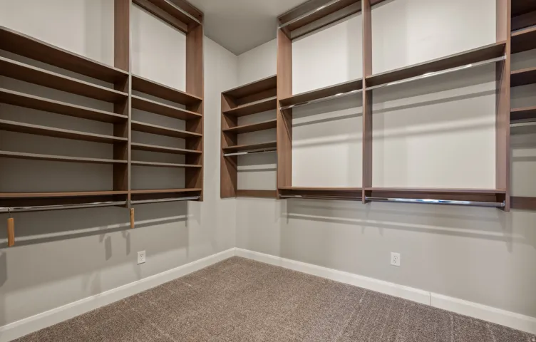 Custom closet system featuring wood-finish shelving and chrome hanging rods