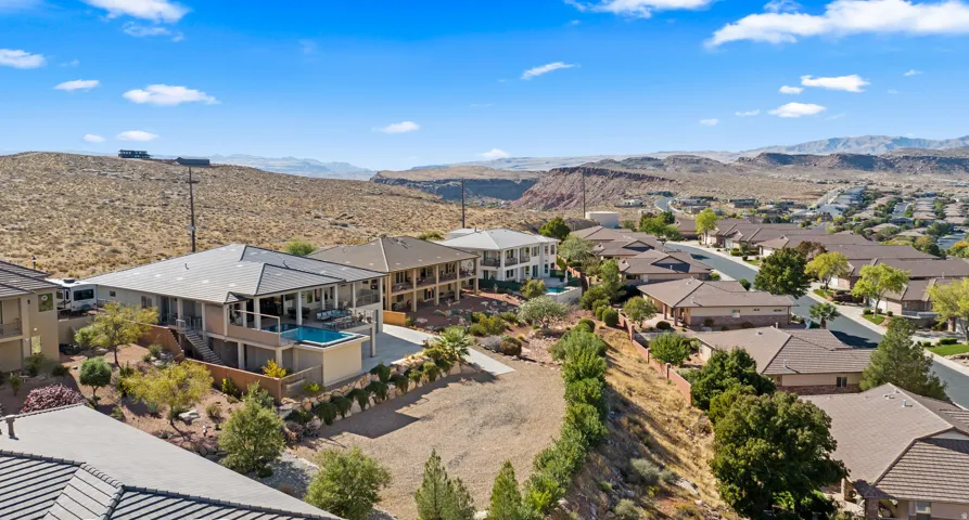 Multi-level residence featuring an integrated pool, covered patio, and desert landscaping
