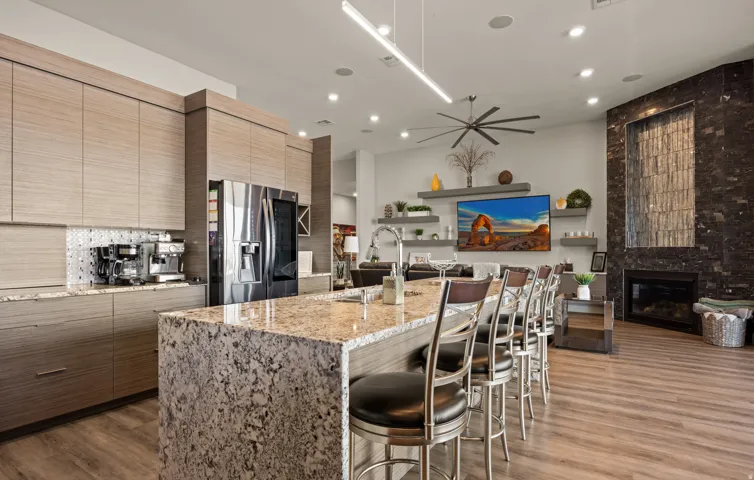 Kitchen with wood-finish cabinetry, granite countertops, and a full-size refrigerator