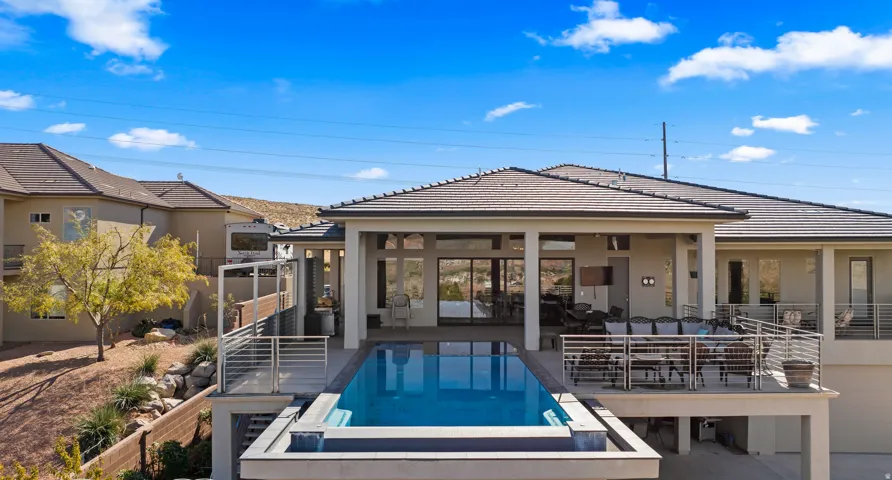 Modern residence showcasing a resort-style saltwater pool with integrated spa, surrounded by composite decking and metal railings