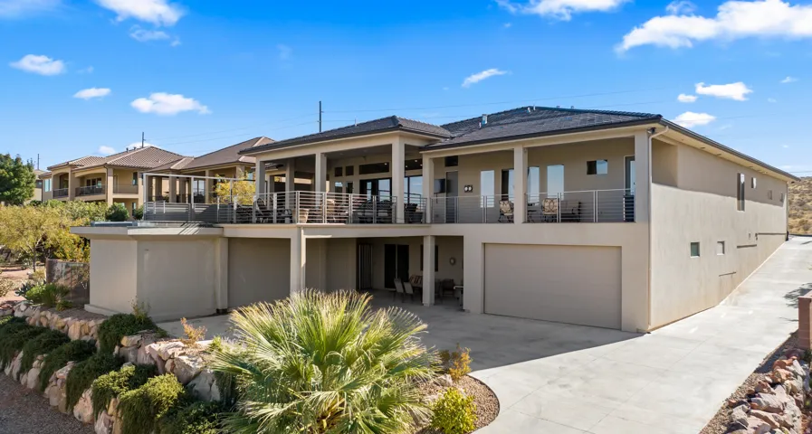 Contemporary stucco exterior with multiple covered patios, a multi-level design, an integrated garage, and a concrete driveway