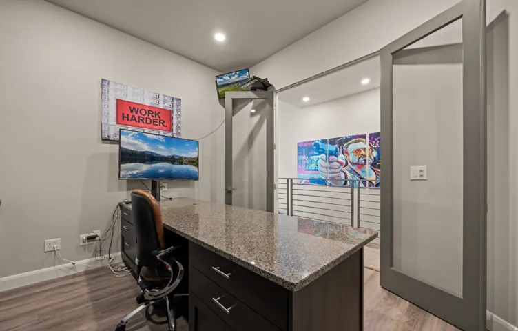 Built-in desk with a stone-finish countertop and dark wood-finish cabinetry