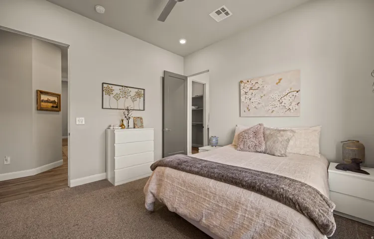 Carpeted flooring, recessed lighting, ceiling fan, and a pocket door revealing shelving