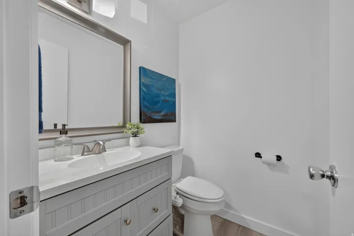 White vanity with beadboard detailing, undermount sink, and brushed nickel faucet