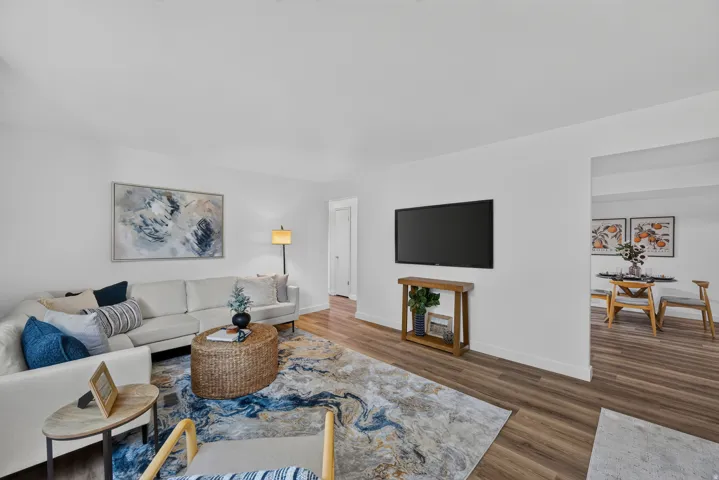 Bright white walls and wood-finish flooring define this living area