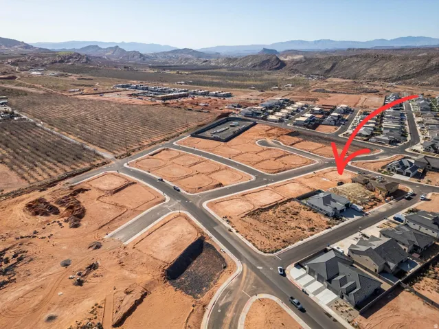 Aerial perspective showcasing a developing neighborhood with established streets and surrounding mountain ranges