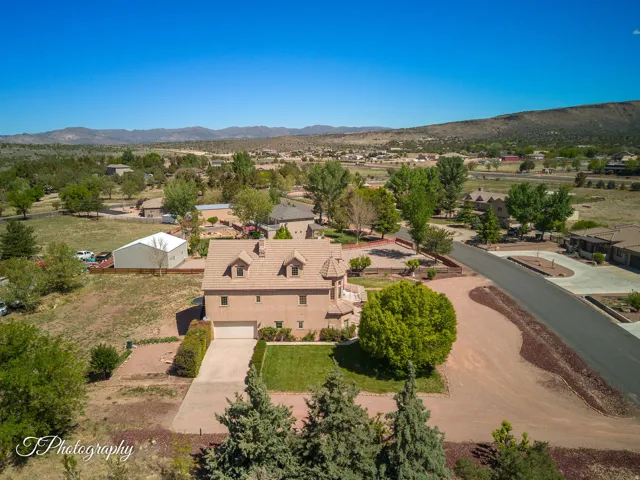 Stunning territorial-style residence showcasing a copper-toned stucco exterior with distinctive curved rooflines and multiple roof peaks