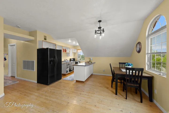 Kitchen with light wood-finish flooring, white cabinetry, and a black French door refrigerator
