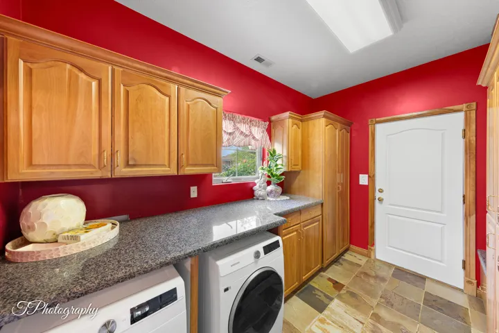 Wood-finish cabinetry, granite-style countertops, and slate-style tile flooring