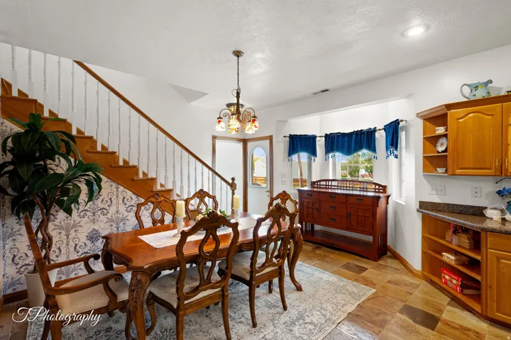 Elegant dining room showcasing rich wood cabinetry, a wood-finish dining table with coordinating chairs, and warm wood-tone flooring