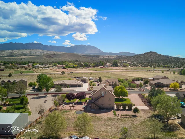 Mountainous landscape, expansive open terrain, residential neighborhood, multiple properties, and mature trees
