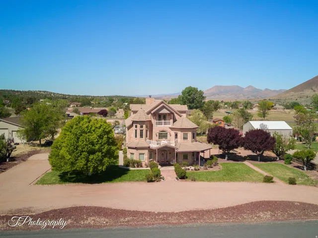 Stucco exterior residence featuring a tiled roof, multiple balconies, and a circular drive