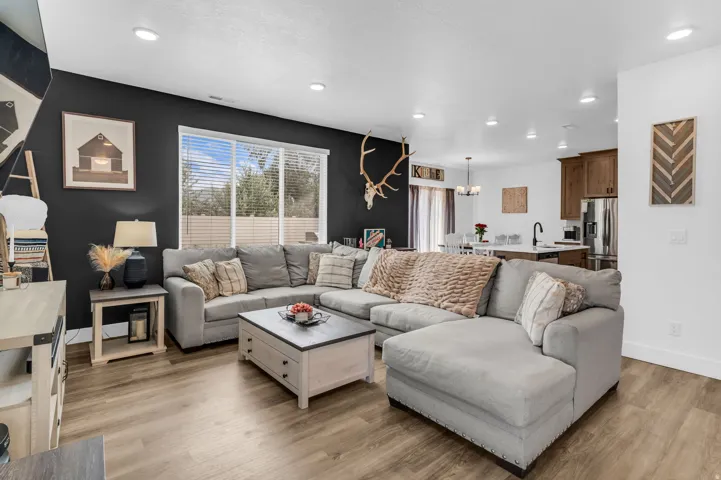 Expansive living area with wood-finish flooring, recessed lighting, and a large window