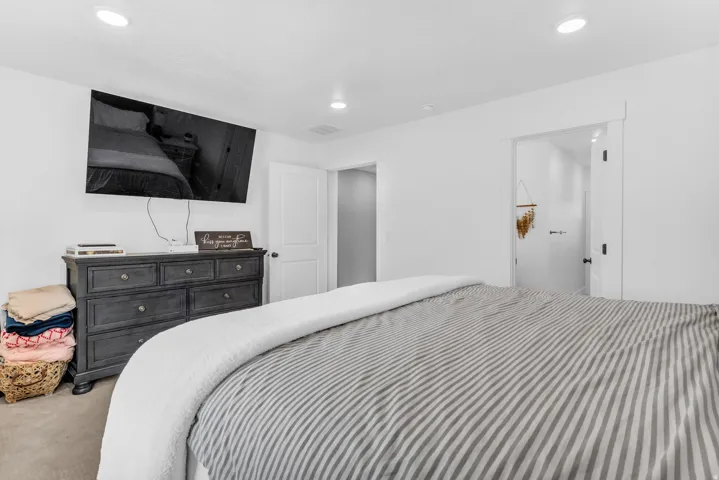 Recessed lighting illuminates the space, featuring white walls and a white door with a dark handle