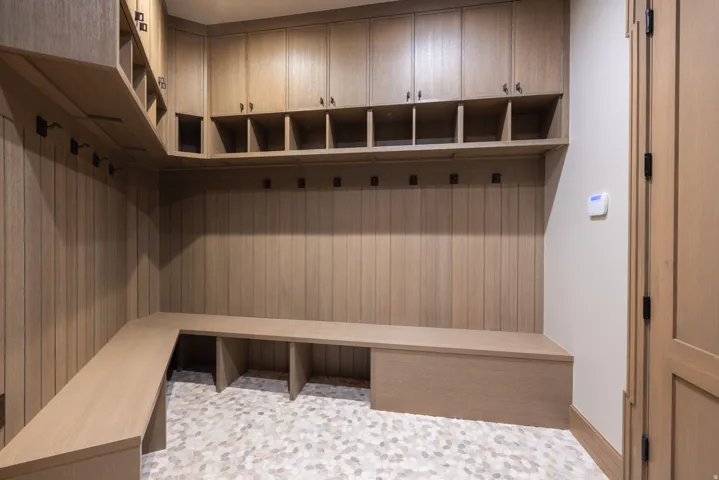 Built-in wood cabinetry with integrated shelving, storage cubbies, and garment hooks