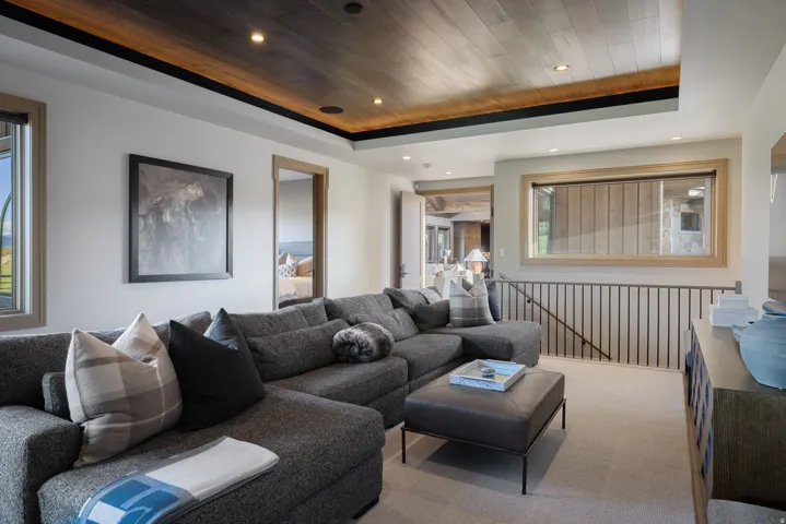 Recessed lighting, wood-finish ceiling, light wood window trim, modern metal railing, and light-toned carpet