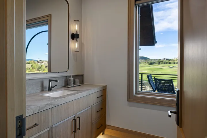 Modern vanity with an integrated sink, dark bronze faucet, and light wood-finish cabinetry